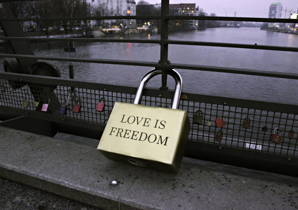Eine Arbeit von Aida Gomez. Ein überdimensioniertes Schloss an einer Brücke mit dem Schriftzug "Love is Freedom".